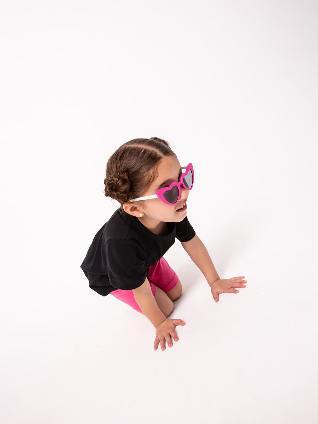 A girl with pink heart-shaped sunglasses, in the studio.